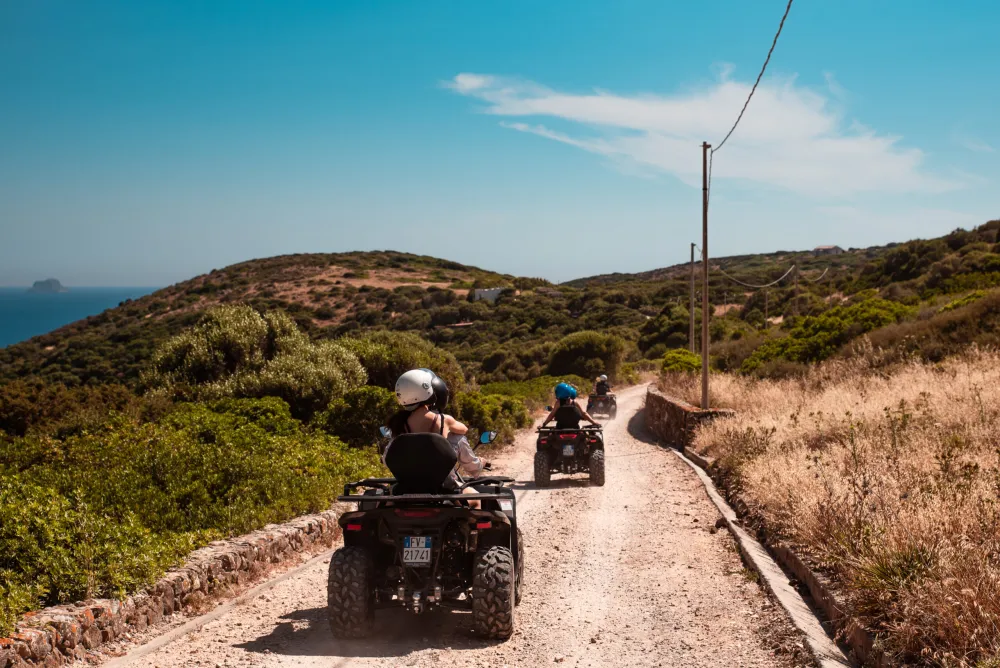 A group of quads on a road through the scrub of Sant'Antioco